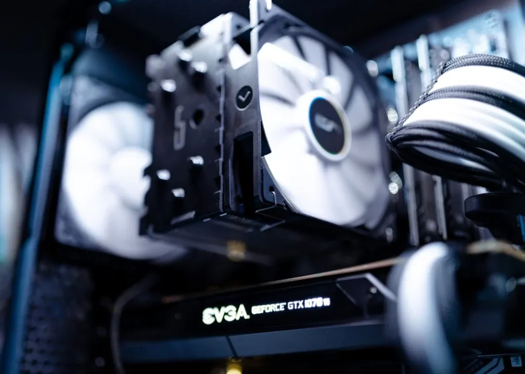 Close-up of a gaming PC build featuring an EVGA GeForce graphics card, CPU cooler with dual fans, and custom cable management in a sleek setup.